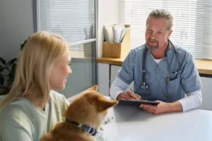 veterinarian-talking-with-pet-owner-who-is-holding-her-cat